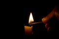 Burning candle in the darkness. Lighting candle with match Royalty Free Stock Photo