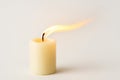 A burning candle with an elongated flame from the wind. Space for text. Royalty Free Stock Photo