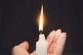 Burning candle in a female hand on a dark background. The concept of carry light in hands Royalty Free Stock Photo