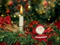 Burning candle on the festive table. Christmas decorations. Santa Claus on the background of the Christmas tree Royalty Free Stock Photo