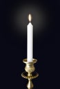 Burning candle in figured gilded candlestick in darkness Royalty Free Stock Photo