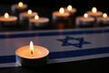 Burning candle and flag of Israel on black table. Holocaust memory day Royalty Free Stock Photo