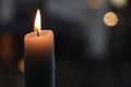 Burning candle in front of a window with lights in de background Royalty Free Stock Photo