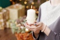 Burning candle in the hands of a girl. Christmas candle. Christmas decor. Woman`s hands holding beautiful candle with fire. Copy Royalty Free Stock Photo