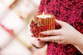 Burning candle in the hands of a girl. Christmas candle. Christmas decor. Woman`s hands holding beautiful candle with fire. Copy Royalty Free Stock Photo