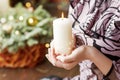 Burning candle in the hands of a girl. Christmas candle. Christmas decor. Woman`s hands holding beautiful candle with fire. Copy Royalty Free Stock Photo