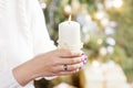 Burning candle in the hands of a girl. Christmas candle. Christmas decor. Woman`s hands holding beautiful candle with fire. Copy Royalty Free Stock Photo