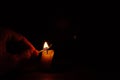 Candel flame. Burning a candle with a match in the dark Royalty Free Stock Photo