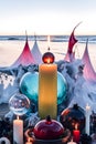 burning candle, moon symbol, amulet and crystal ball lying on a light natural background with the sea in the background