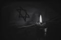 A burning candle next to the star of David Royalty Free Stock Photo