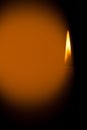 A burning candle at night. Symbol of life, love and light, protection and warmth. Candle flame glowing on a dark background.