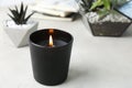 Burning candle and plants on white table Royalty Free Stock Photo