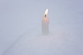 Burning candle on real snow. Christmas background
