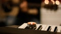 A burning candle with red wax stands on a musical synthesizer Royalty Free Stock Photo