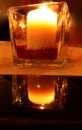 Burning candle with a reflection