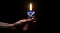 a burning candle set against the backdrop of the Israel flag, in observance of International Holocaust Remembrance Day.