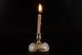 Burning candle on a stand on a black background Royalty Free Stock Photo