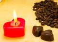 Burning candle, two heart shaped candies and cofee Royalty Free Stock Photo