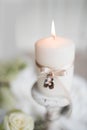 Burning candle with wedding rings