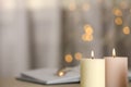 Burning candles against blurred lights, closeup. Space for text Royalty Free Stock Photo