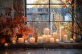 Burning Candles With Autumn Leaves on a Windowsill Royalty Free Stock Photo