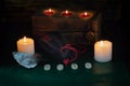 Burning candles, a bag with runes and a formula of the symbols Fehu, Mannaz, Tiwaz and Wunjo