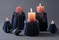 Burning candles in black paper candlesticks on a gray background Royalty Free Stock Photo