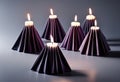 Burning candles in black paper candlesticks on a gray background Royalty Free Stock Photo