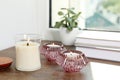 Burning candles with books and houseplant on wooden window sill Royalty Free Stock Photo