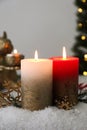 Burning candles and Christmas decor on artificial snow Royalty Free Stock Photo