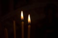 Burning candles in church. Burning candles shining in dark background. Copy space. Royalty Free Stock Photo