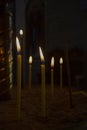 Burning candles in church. Religious concept. Many burning candles shining in dark background. Royalty Free Stock Photo