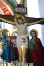 Burning candles in the church, wax candles lit on the background of a cross with a crucifix, Golgotha Royalty Free Stock Photo