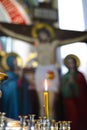 Burning candles in the church, wax candles lit on the background of a cross with a crucifix, Golgotha Royalty Free Stock Photo