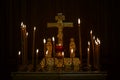 Burning candles with a cross and a crucifix in a Christian church in the dark. Close-up. Faith and religion Royalty Free Stock Photo