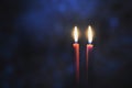 Burning candles in Darkness. Two red candles on black background with blue light bokeh Royalty Free Stock Photo