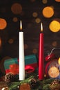 Burning candles, fir branches, gift box and alarm clock on wooden table, bokeh effect Royalty Free Stock Photo