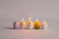 Burning candles in the form of eggs. Candles of different colors Royalty Free Stock Photo