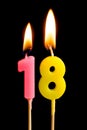 Burning candles in the form of 18 eighteen figures numbers, dates for cake isolated on black background. The concept of celebrat Royalty Free Stock Photo