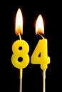 Burning Candles In The Form Of 84 Eighty Four Numbers, Dates For Cake Isolated On Black Background. The Concept Of Celebrating A