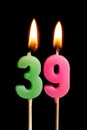Burning candles in the form of 39 thirty nine numbers, dates for cake isolated on black background. The concept of celebrating a