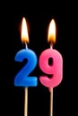 Burning candles in the form of 29 twenty nine numbers, dates for cake isolated on black background. The concept of celebrating a