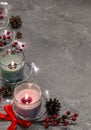 Burning candles with garland, mistletoe, pine cones, red bow on Royalty Free Stock Photo