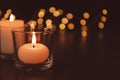 Burning candles in glass holders on table against blurred lights, space for text Royalty Free Stock Photo