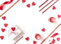 Burning candles, heart-shaped figures, wooden sticks, ribbon, gift in crumpled wrapping paper are on a white background.