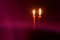 Burning candles at Night. Two red candles on dark pink and black background Royalty Free Stock Photo