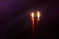 Burning candles at Night. Two red candles on dark purple background Royalty Free Stock Photo