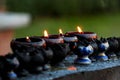 Burning candles and oil lamps in a buddhist temple in Thailand Royalty Free Stock Photo