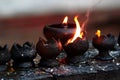 Burning candles and oil lamps in a buddhist temple in Thailand Royalty Free Stock Photo