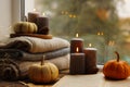 Burning candles, open book and stack of soft sweaters on windowsill. Autumn atmosphere Royalty Free Stock Photo